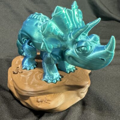 Silky Blue Triceratops standing on a brown base.